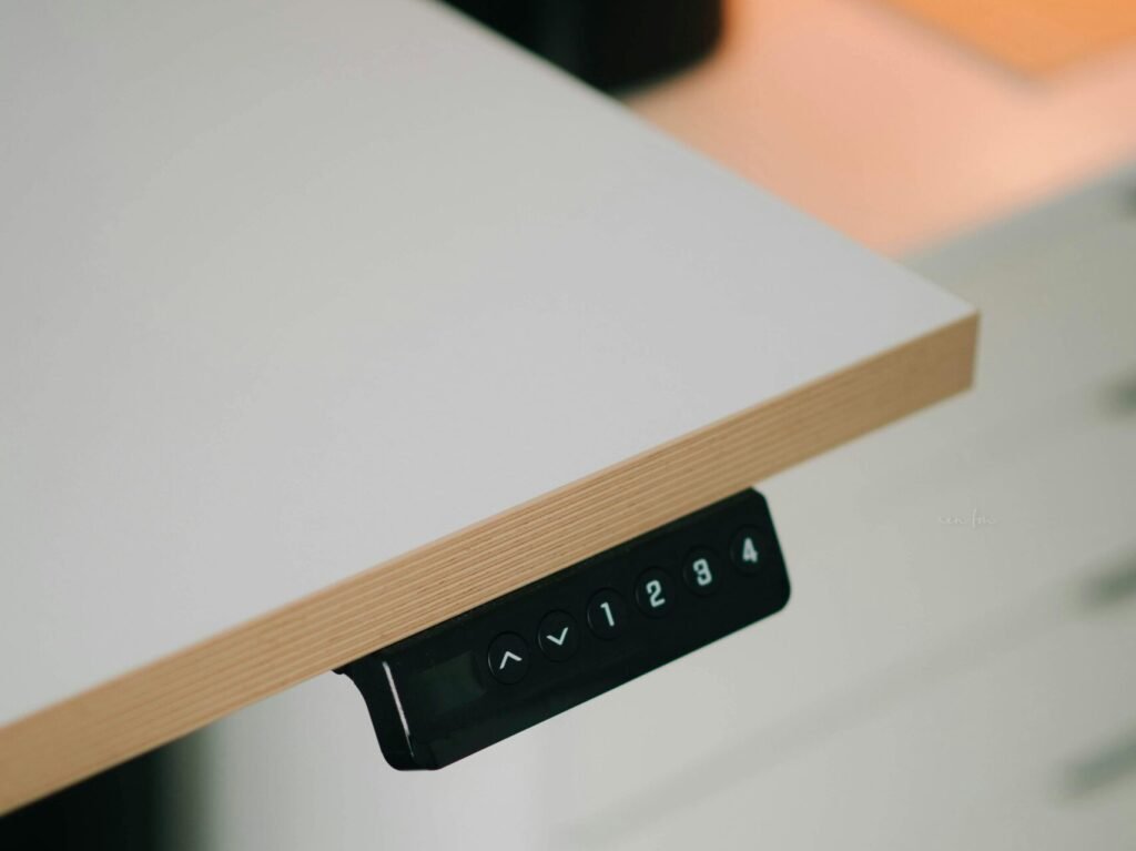 Close-up of a modern adjustable height desk with integrated control panel for height adjustment.